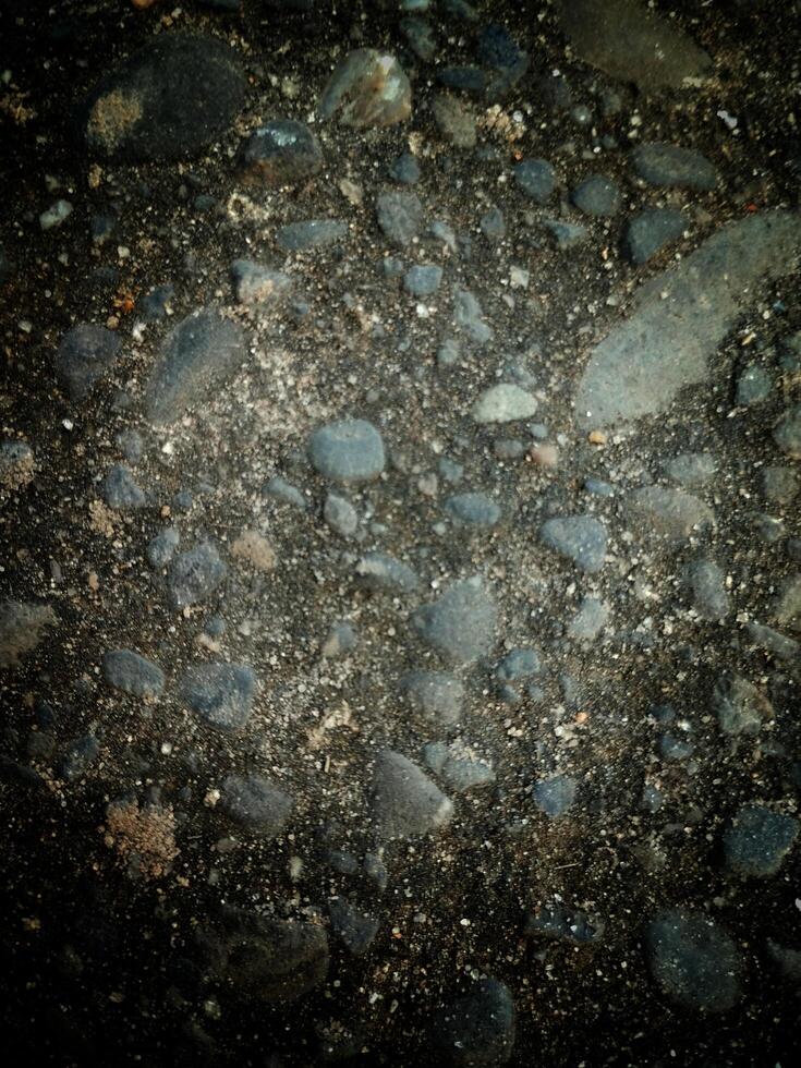 A collection of rocks scattered on the ground, varying in size, shape, color, and texture. photo