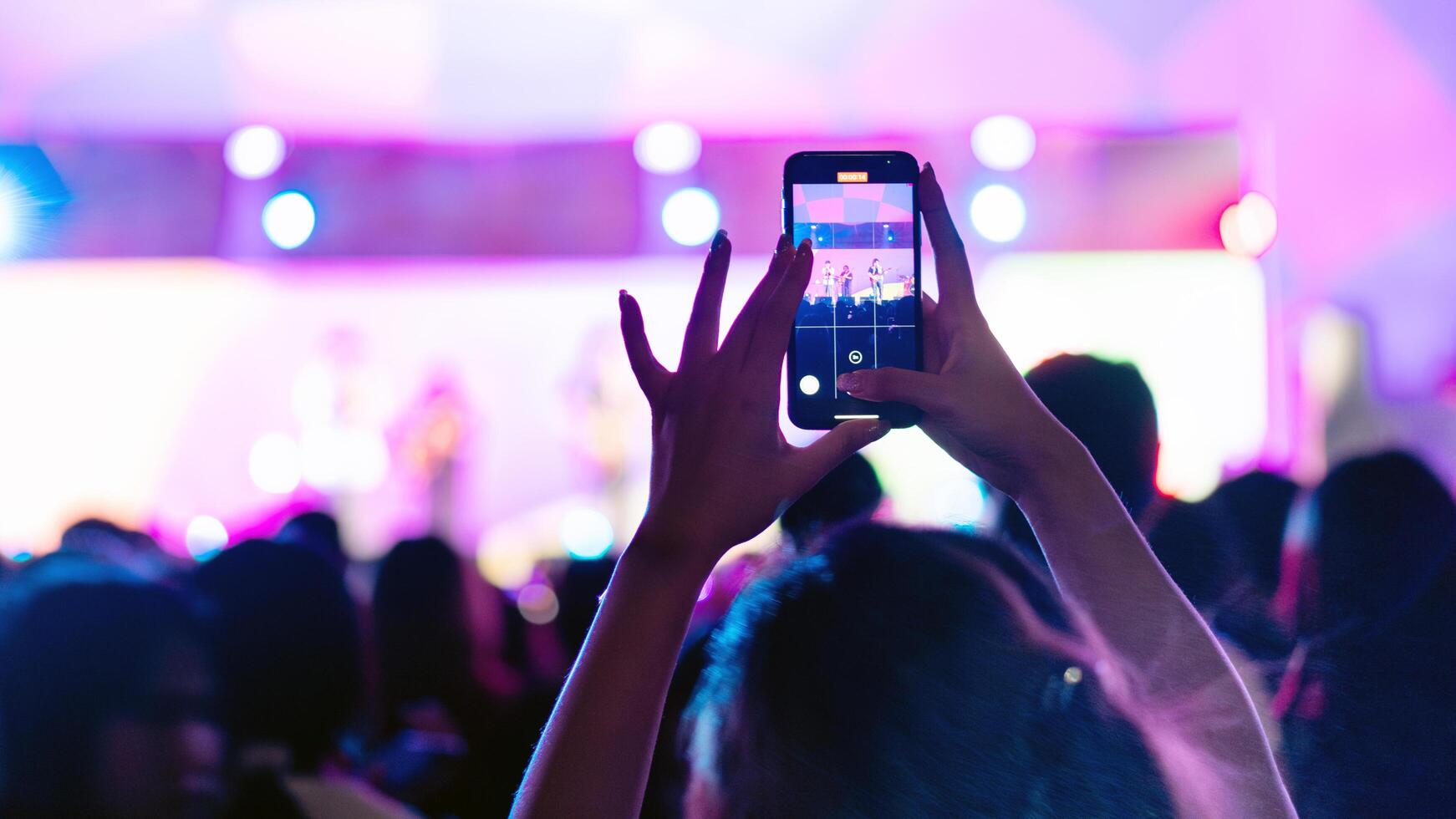 People holding smart phone and recording and photographing in concert , silhouette of hands with mobile , event background concept photo