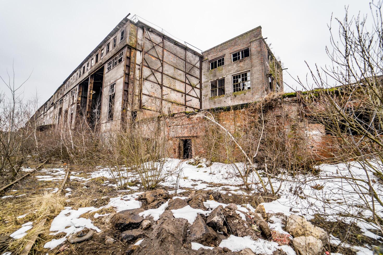 Concrete ruins in industrial district. Ruins of abandoned old broken industrial factory or warehouse buildings after disaster photo