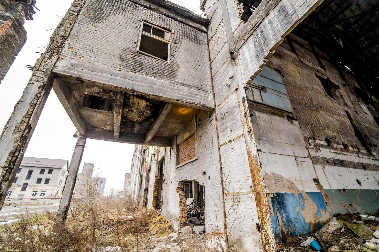 Broken-down destroyed industrial building outside. Old, ruined and collapsed abandoned building with columns by traditional cement bricks and stones. photo