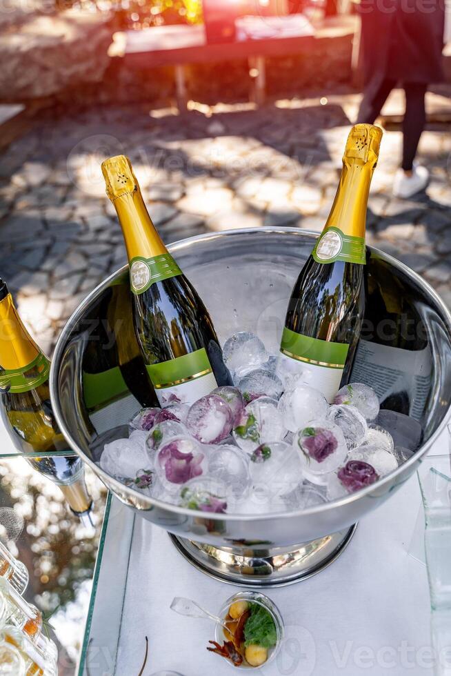 Cold champagne lying on ice. Cold white wine celebration. photo