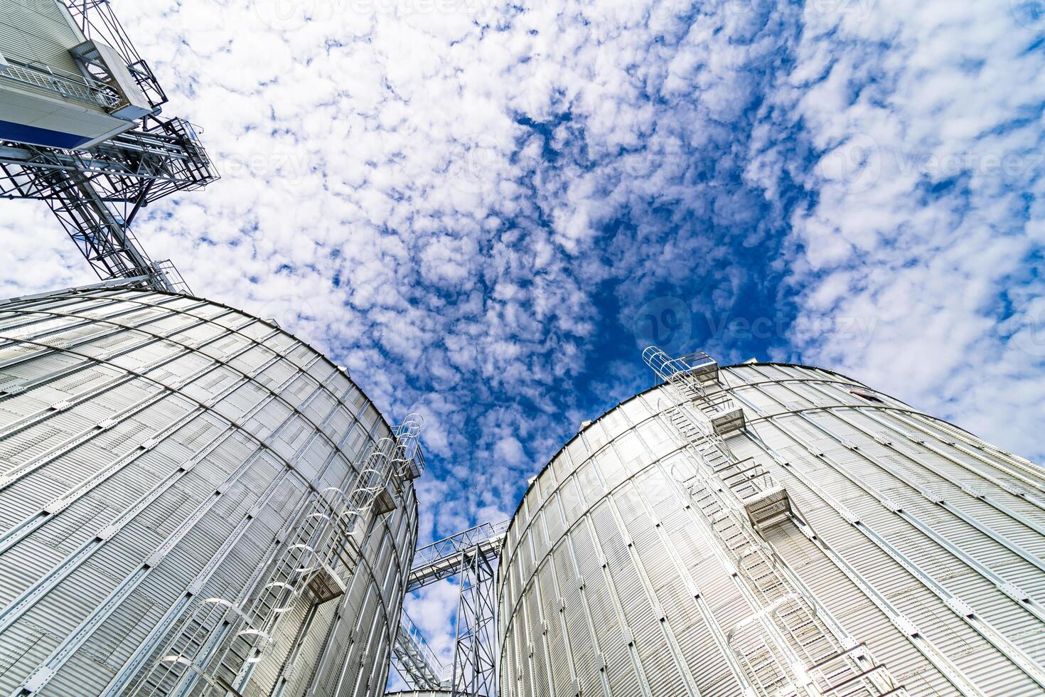 Great cylindric warehouse with blue sky. Big metallic industial construction. Steel store. photo