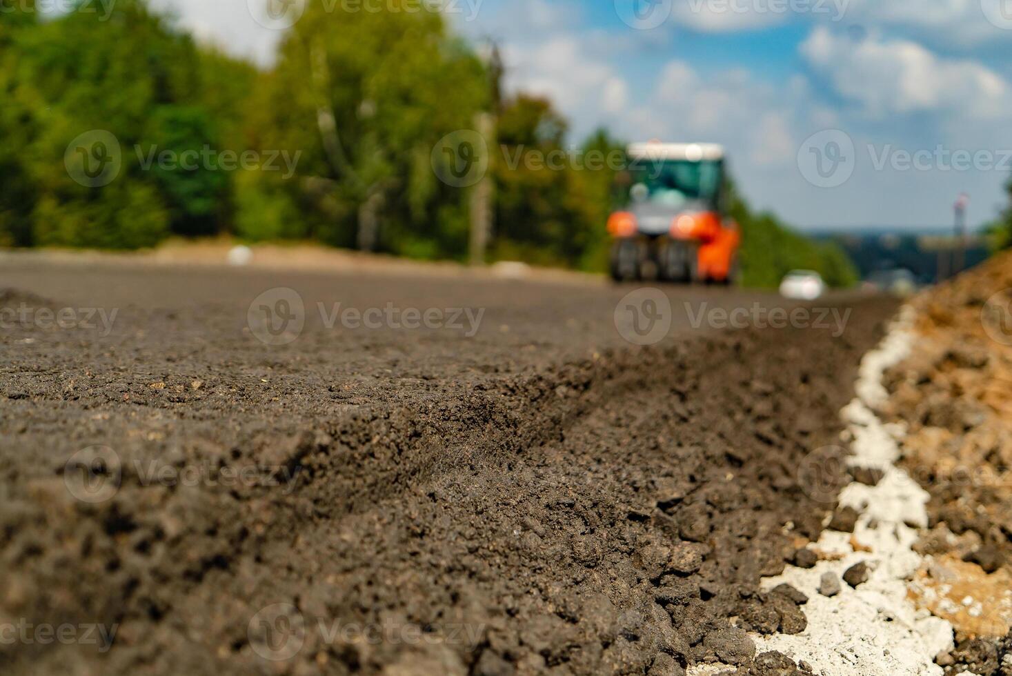 tamping asphalt by vibratory roller machine on the road. Close-up photo