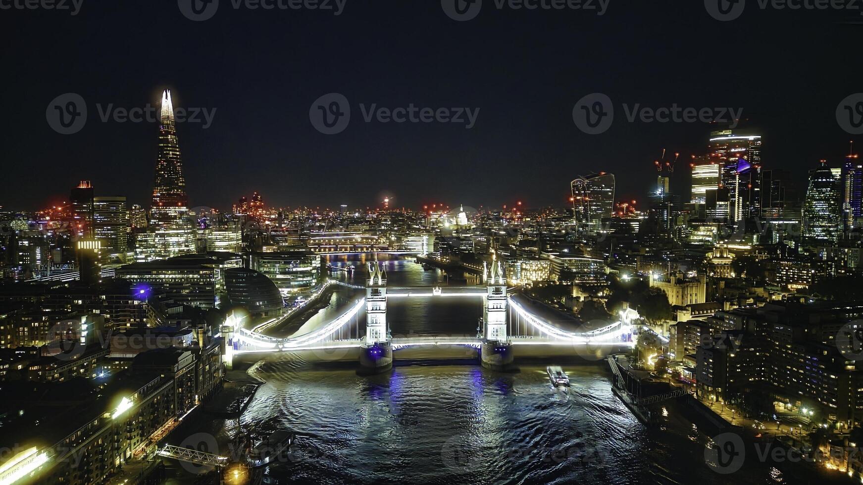 Scenic aerial view of the Tower Bridge and city at night in London photo