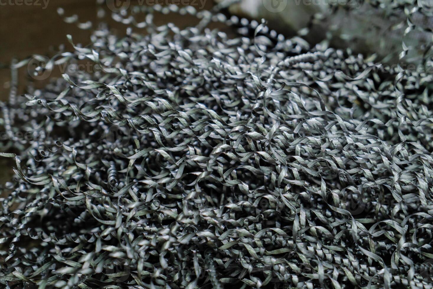 spiral steel shavings lay on the floor into the room of factory. Close-up photo