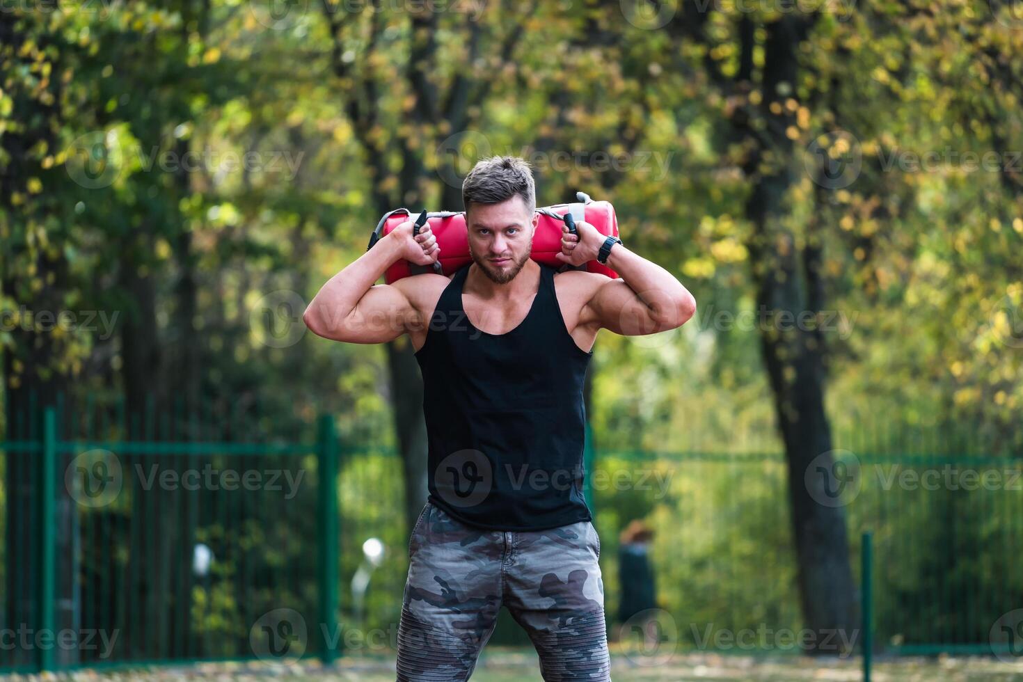 Handsome bodybuilder training outdoor. Fitness young man working out outdoor. photo