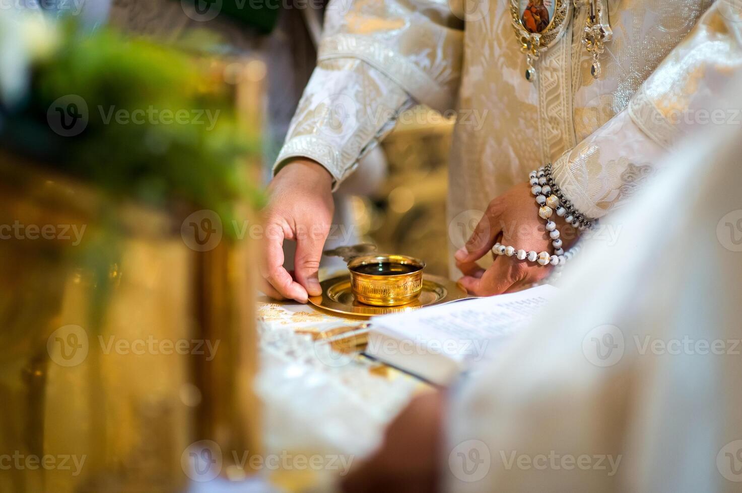 Wedding church ceremony concept. Golden cup with vine on the plate. Blurred background. Closeup. photo