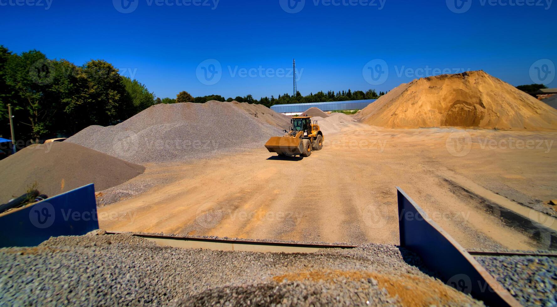 Sand quarry, excavating equipment, bulldozer with heap of sand and gravel in background. Selective focus. photo