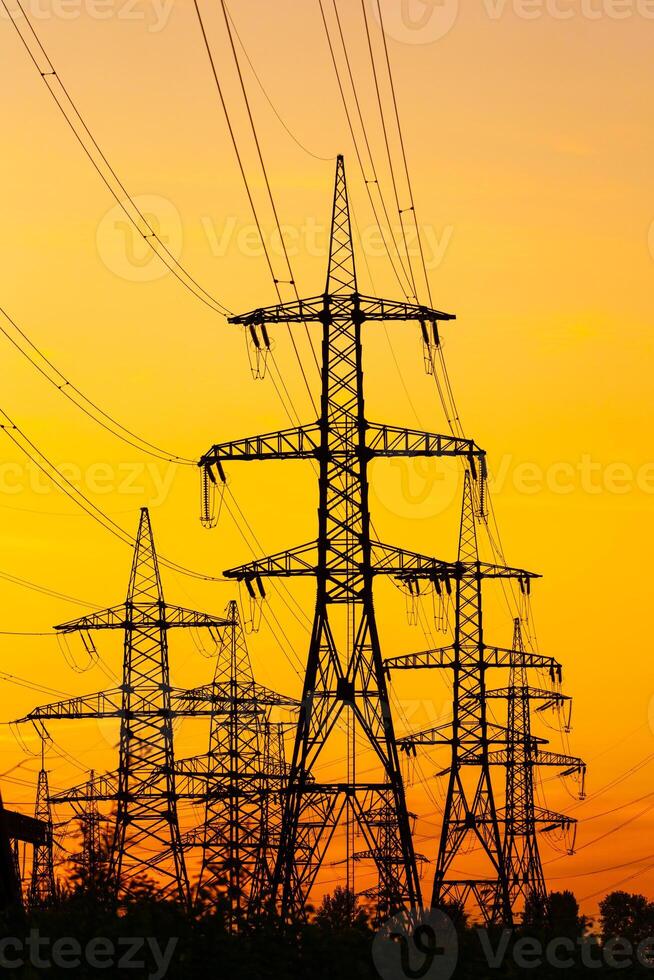 Energy Distribution Network - Electricity Pylons against Orange and Yellow Sunset. Selective focus. photo