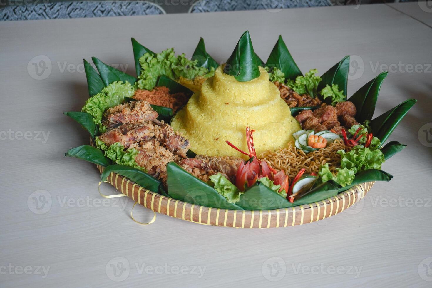 Nasi Tumpeng, Java traditional food isolated on white background. Indonesian rijsttafel of yellow rice with side dishes from several regional cuisines in the country for Independence celebration. photo