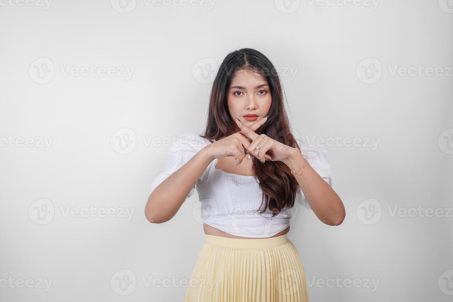 joven asiático mujer aislado en blanco fondo, mira grave, gesticulando disminución o No firmar por su mano, asustado y nervioso. foto