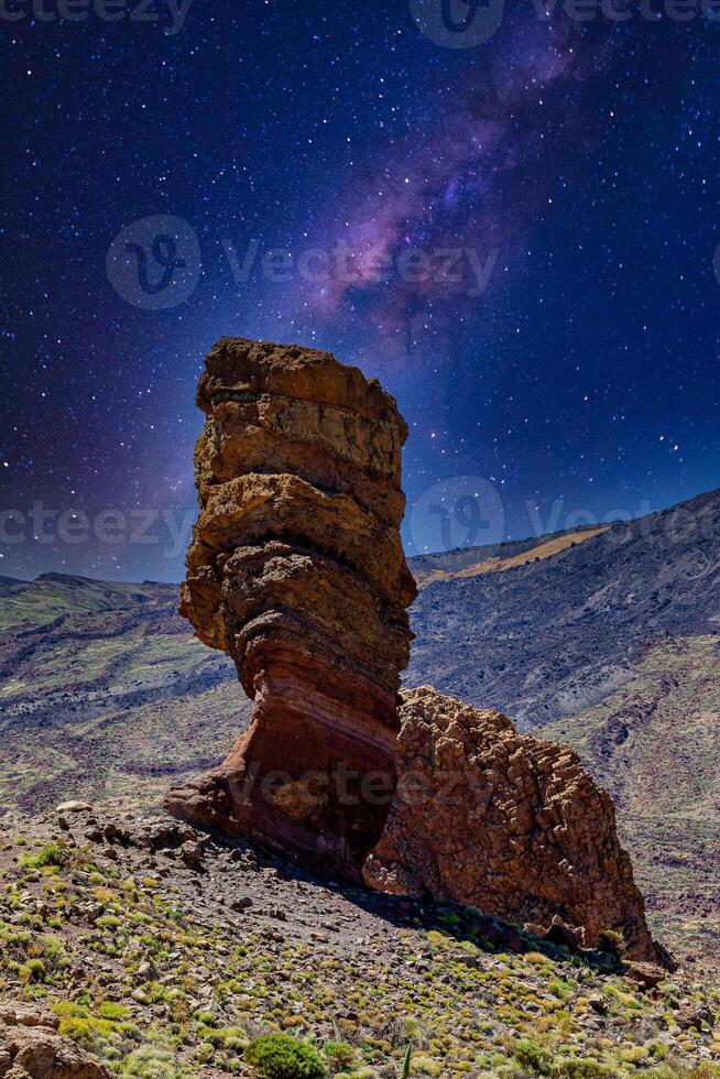 majestuoso rock formación debajo un estrellado noche cielo con el lechoso camino galaxia visible en el teide, nacional parque, tenerife foto