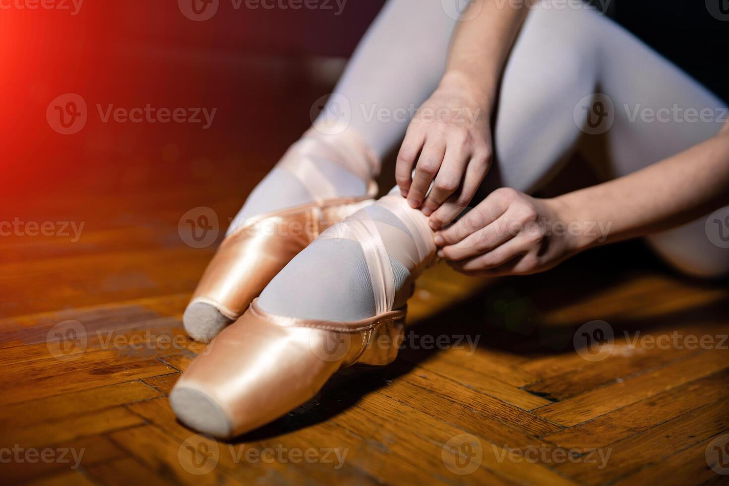 Young ballerina sitting, legs and golden shoes. Classical art concept. Preparing for dance. closeup. photo