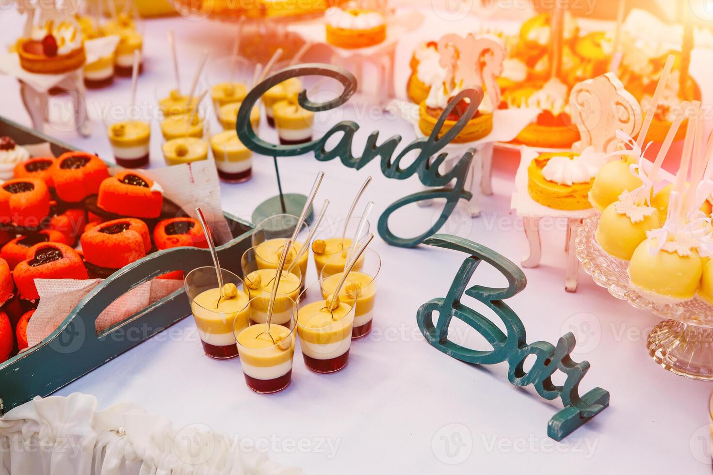 Candy bar, table with colorful sweets, candies, dessert. Buffet with delicious cupcakes, cake pops, biscuits, sweets. photo