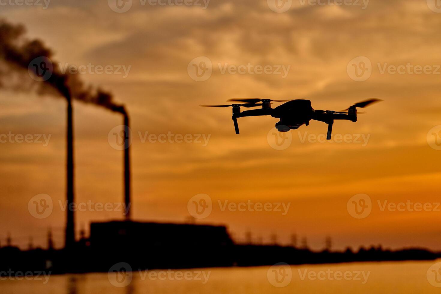 drone silhouette against the background of the sunset. Flying drone in the evening sky photo