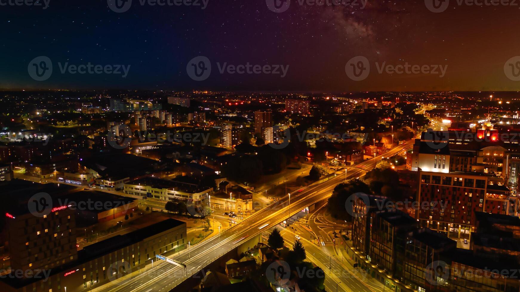 noche paisaje urbano con iluminado calles y urbano horizonte debajo un estrellado cielo en leeds. foto