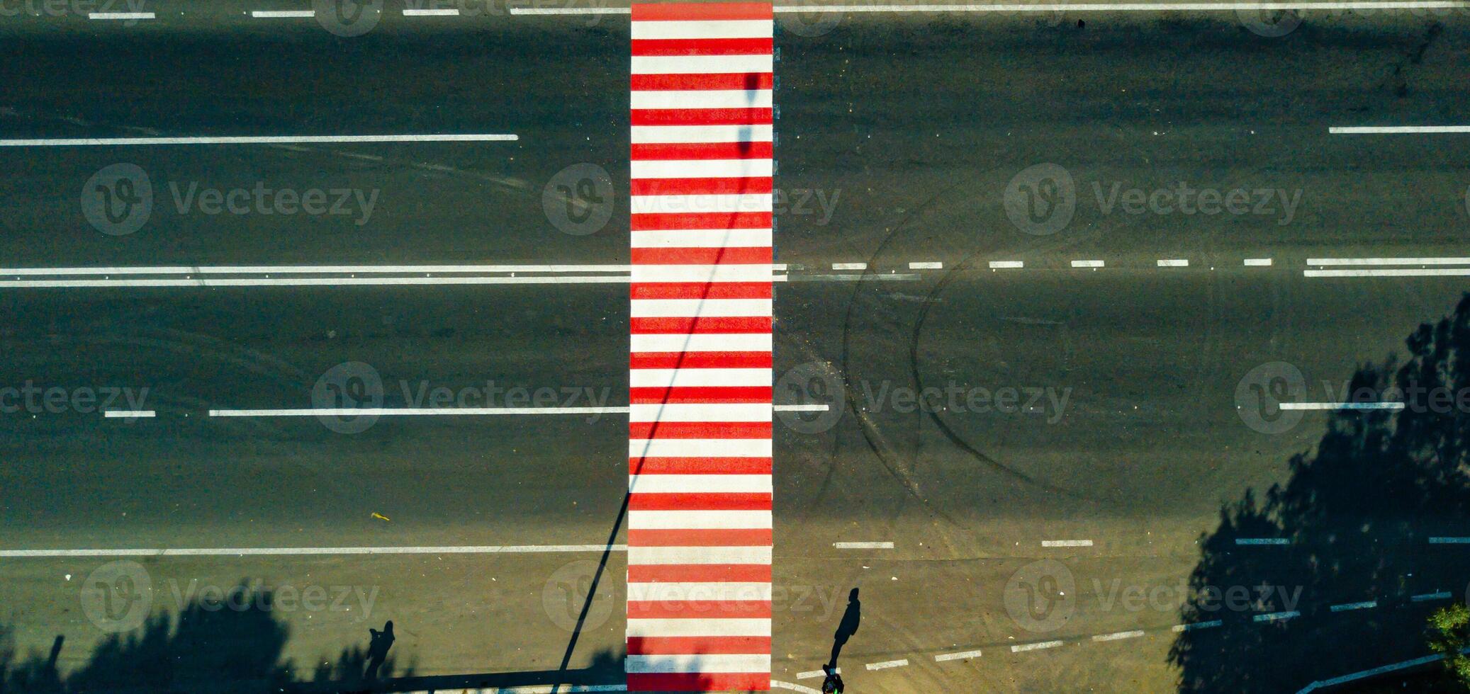 road with a pedestrian crossing of white and red color from the height. Close-up photo