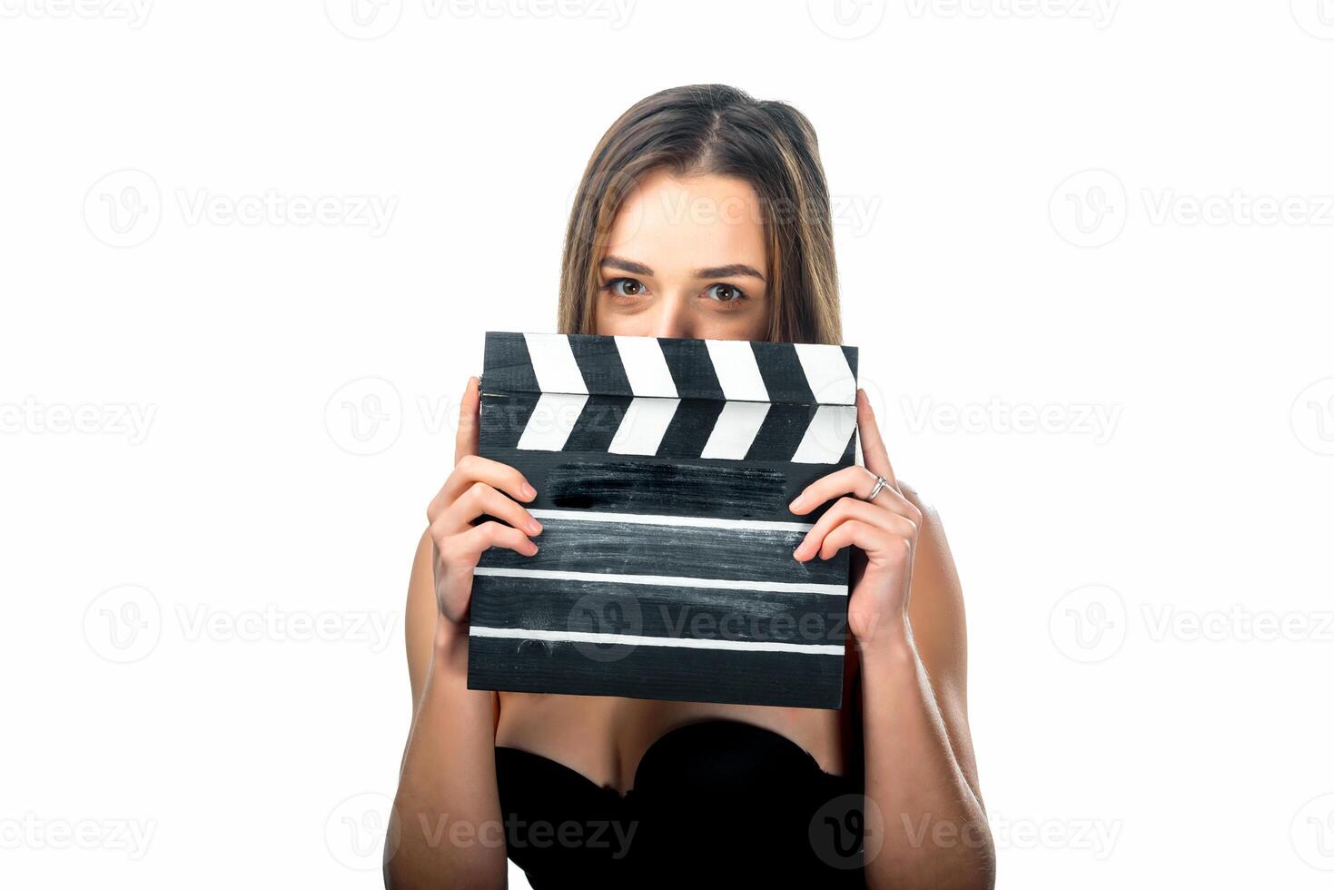 Girl with clapper board. People's emotions. Isolated background. Close up. Beauty hides behind the film numerator. Closeup. photo