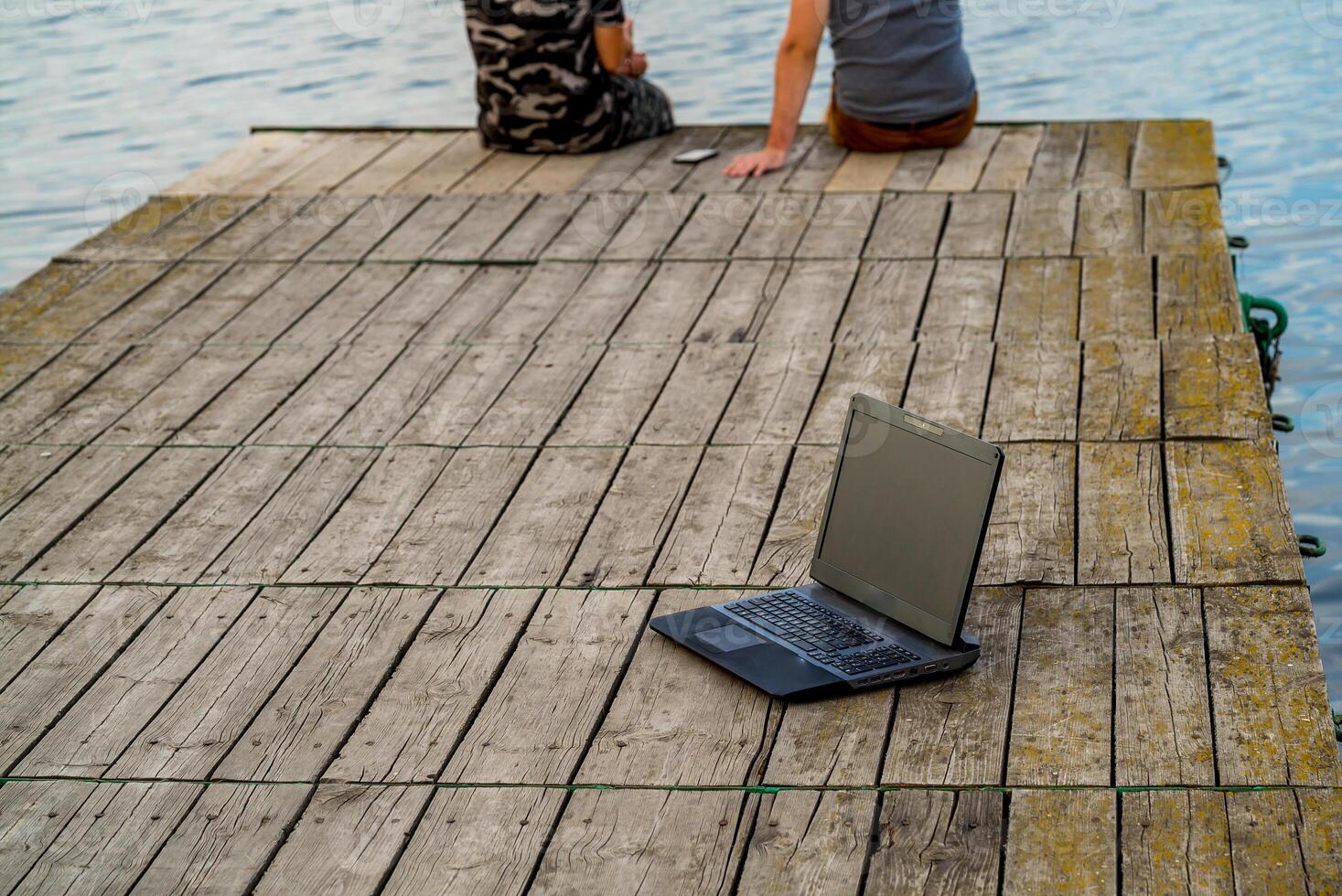 Laptop on the pier. Man working on pier photo