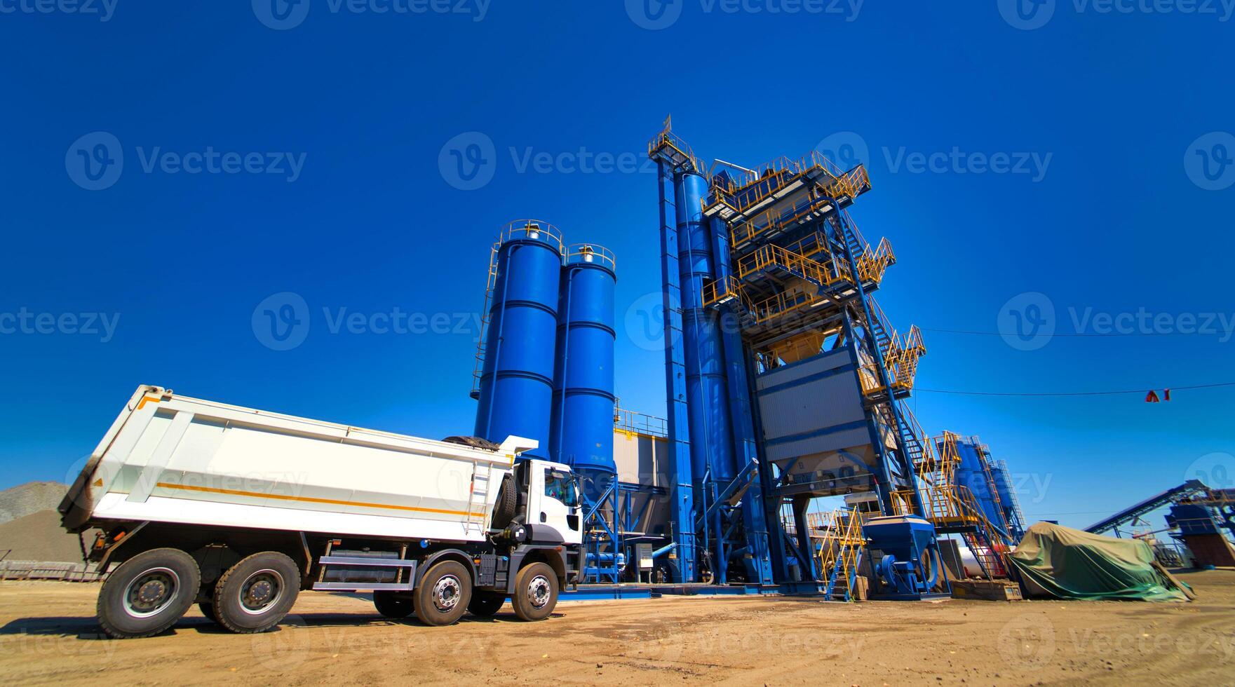 The truck is ready to load gravel or sand in concrete station. Asphalt production, Road construction. Blue sky background. photo