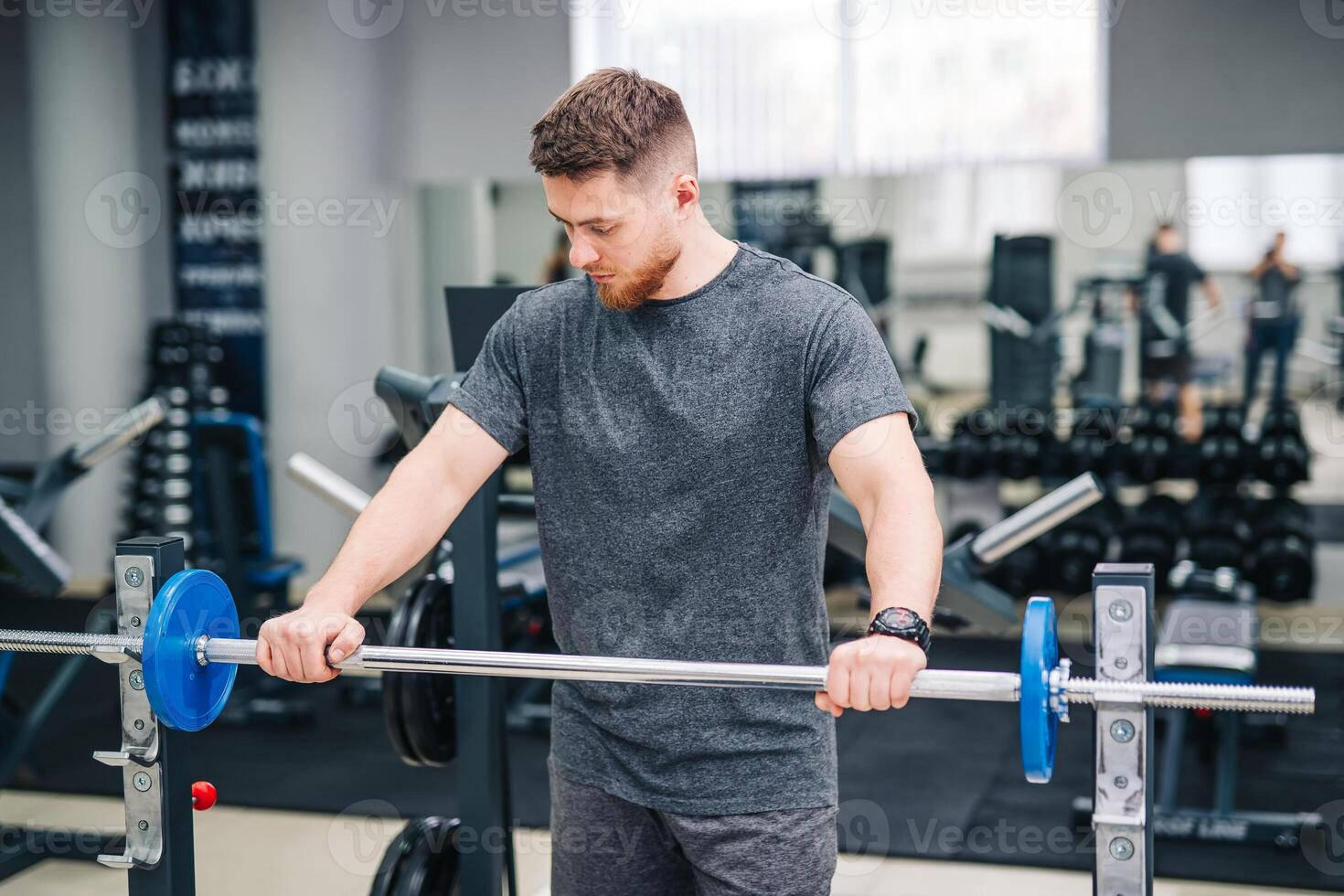 Healthy handsome young trainer working in the gym. Fitness attractive man training in the gym. photo