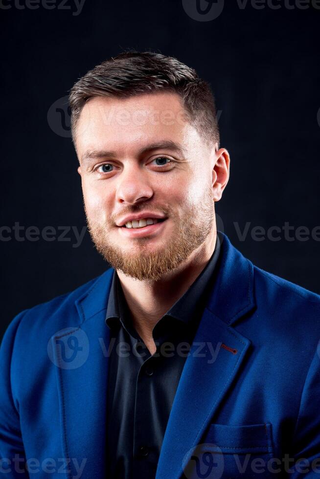 Attractive young guy posing in studio. Portrait of a handsome man with light beard and nice face. Confident look to the camera. Vertical photo