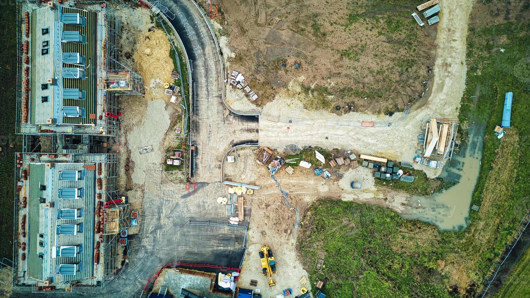 Aerial view of a construction site with building foundations and machinery. photo