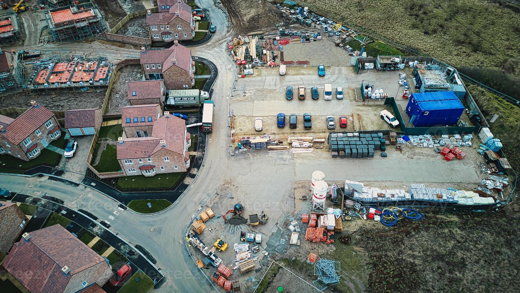 Aerial view of a construction site with materials and equipment near residential houses. photo