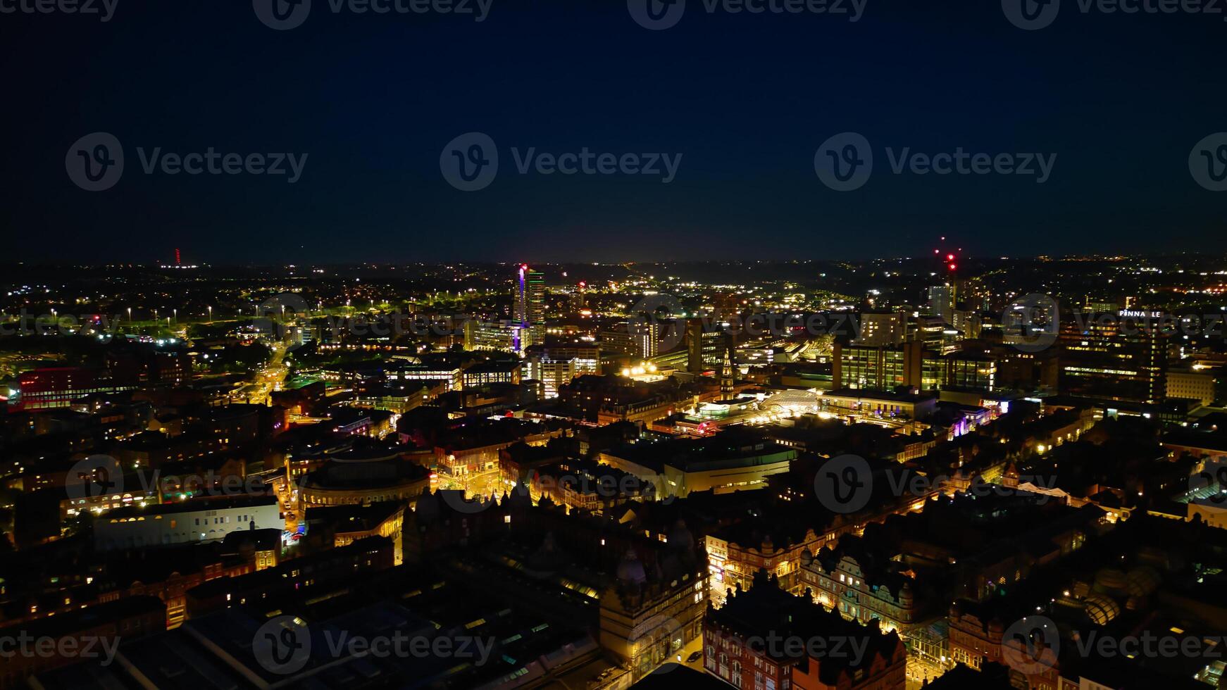 Aerial night view of a cityscape with illuminated buildings and streets, showcasing urban nightlife and architecture in Leeds. photo