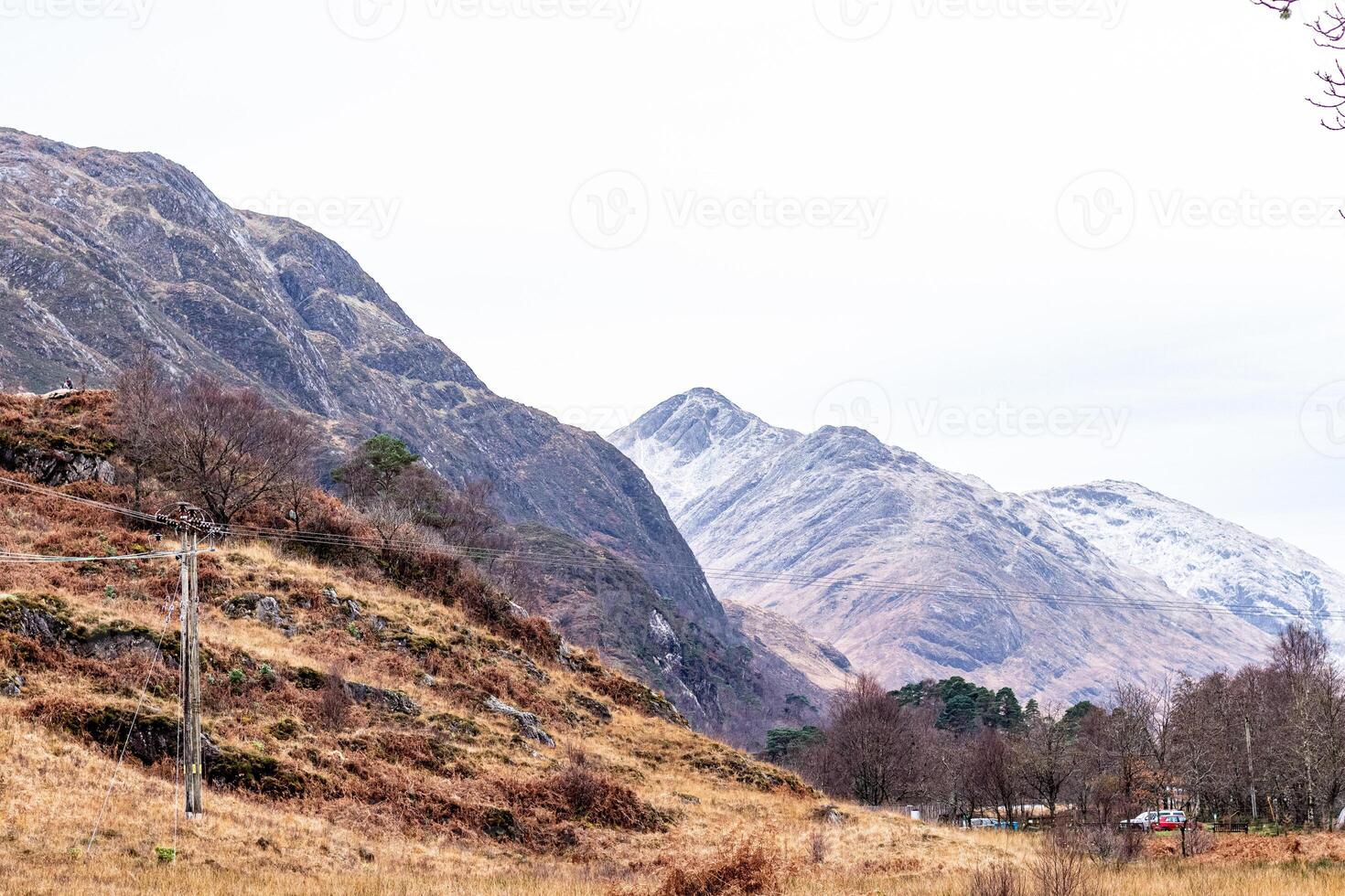 Scenic view of rolling hills with sparse vegetation under a cloudy sky, showcasing the tranquil beauty of a mountainous landscape in Scotland. photo