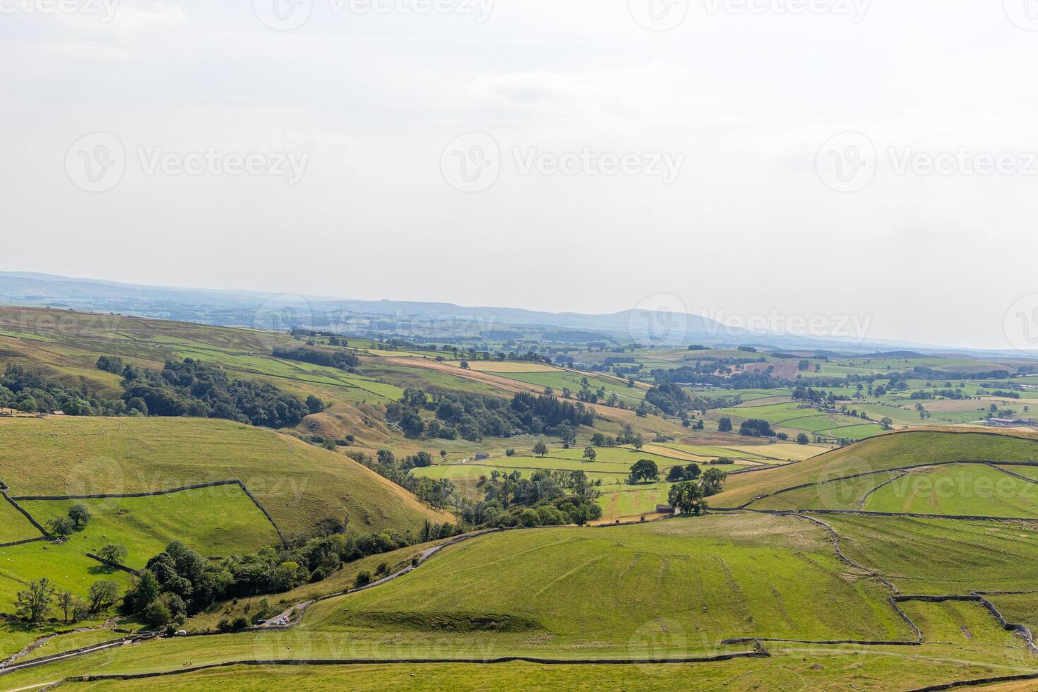 Serene rolling hills with lush green fields under a clear sky, depicting tranquil rural landscape. photo