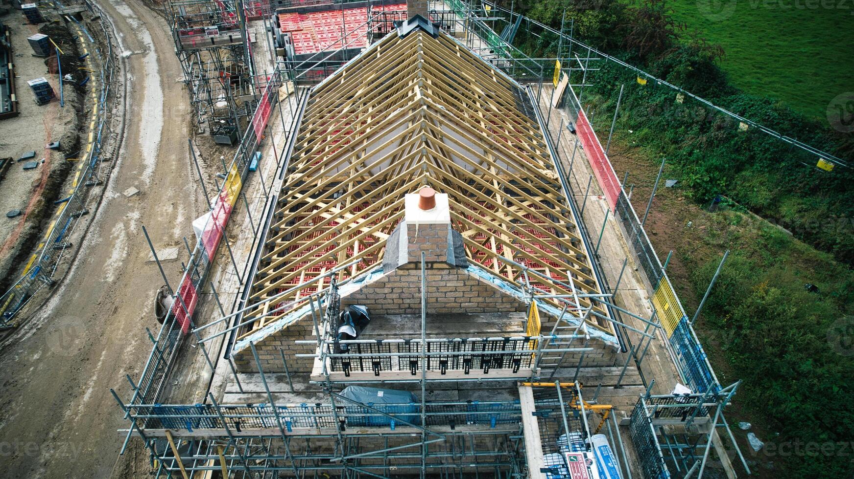 Aerial view of construction site with wooden roof framework and scaffolding. photo