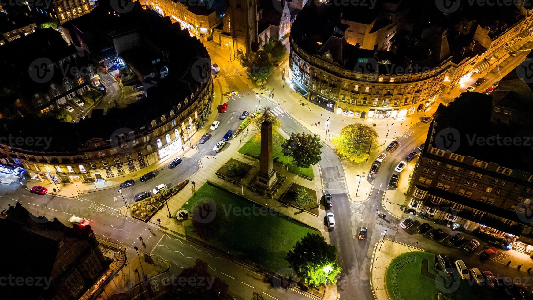 Aerial night view of a bustling city intersection with illuminated streets and buildings in Harrogate, North Yorkshire. photo