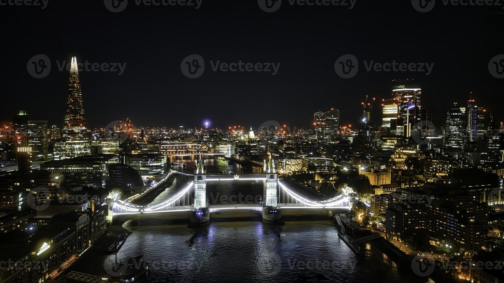 Scenic aerial view of the Tower Bridge and city at night in London photo