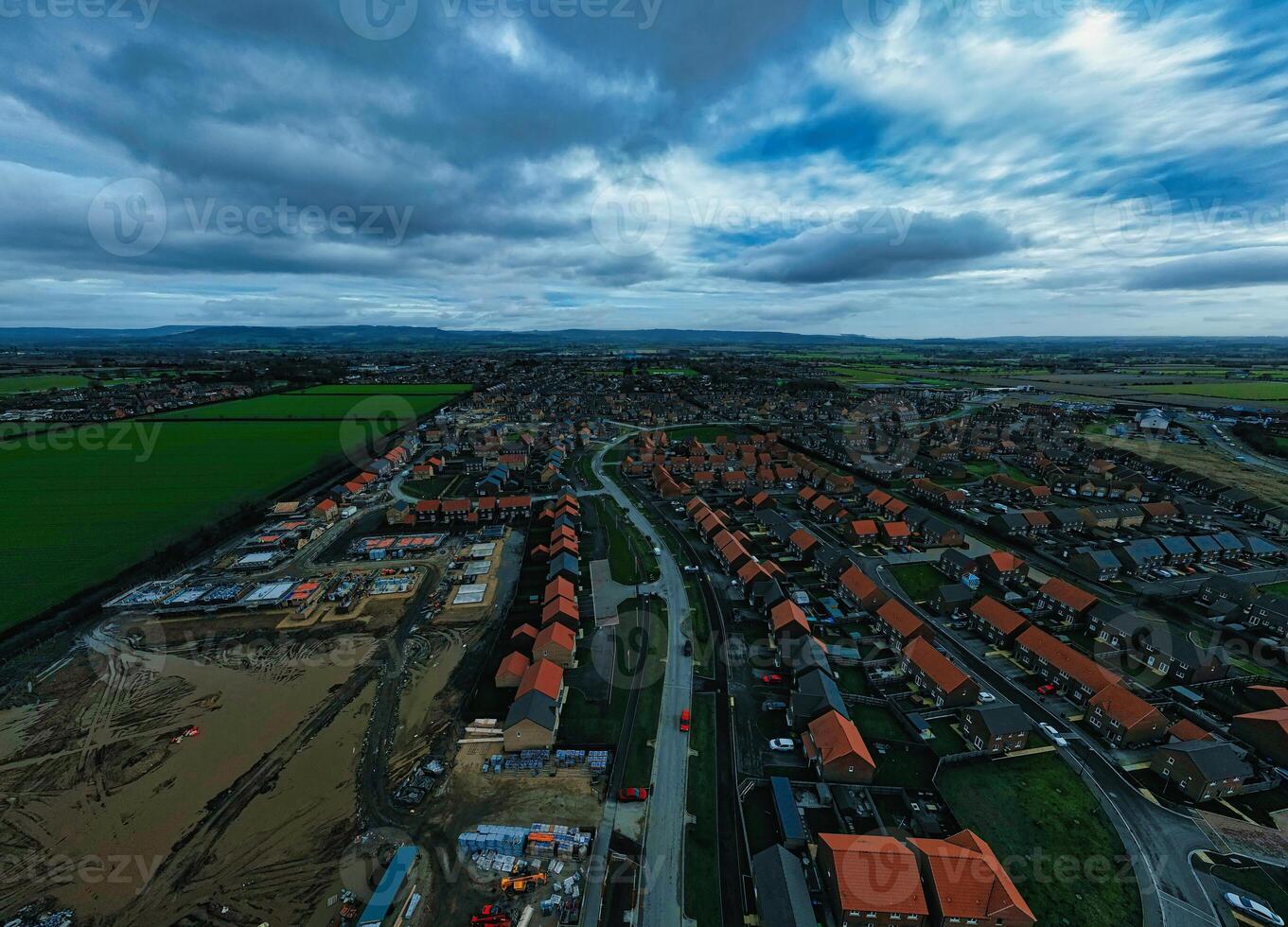 Aerial view of a suburban neighborhood with rows of houses under a dramatic cloudy sky. photo