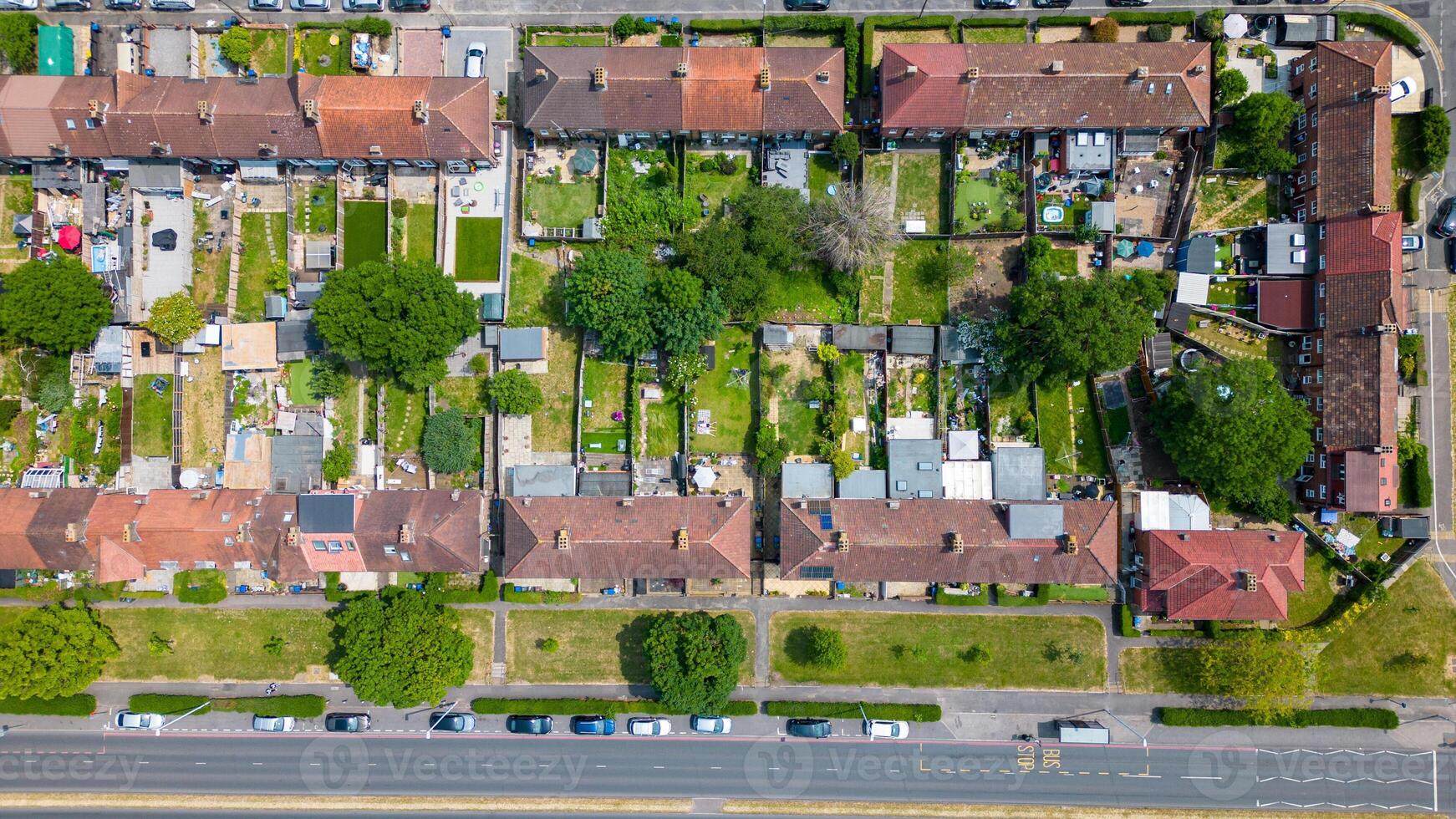 aéreo ver de un suburbano barrio con filas de casas y verde patios traseros junto a un calle en Londres. foto