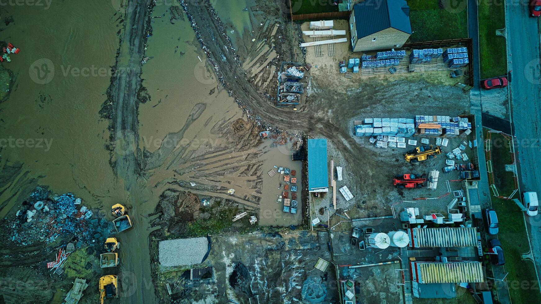 Aerial view of a flooded industrial area with submerged vehicles and buildings. photo
