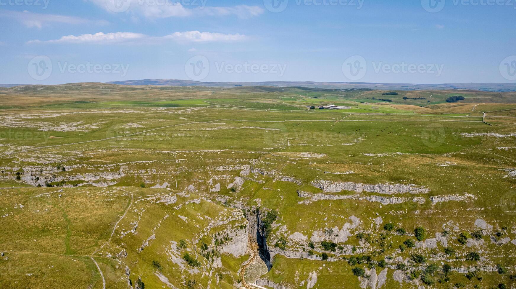 Aerial view of a vast, green limestone karst landscape under a clear blue sky. photo