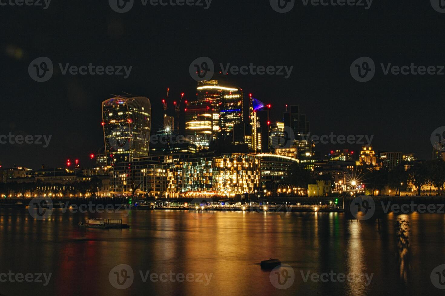 Night cityscape with illuminated buildings reflected on water surface. photo