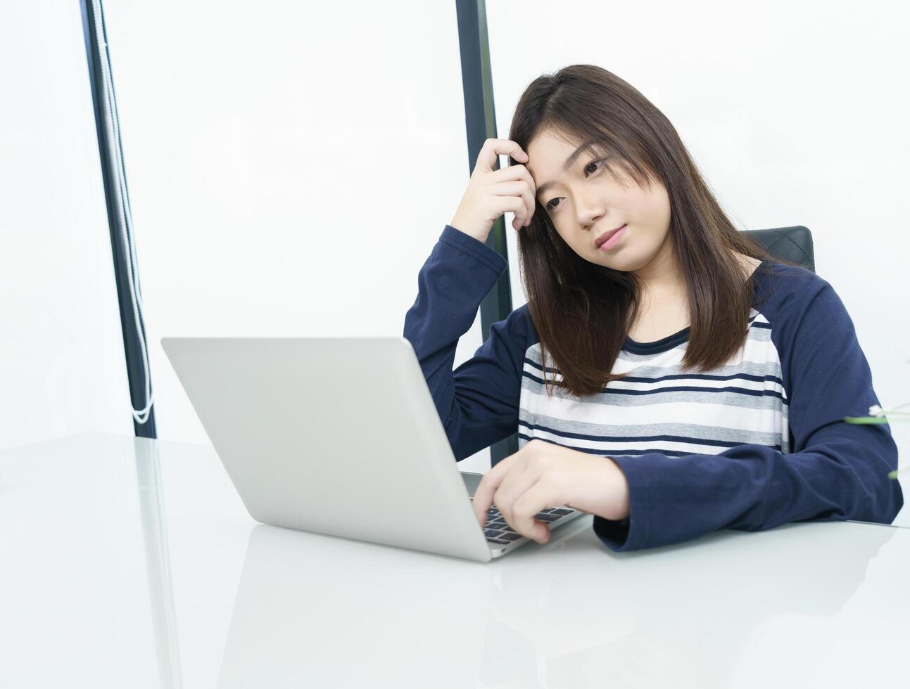 Young female student  sitting in living room and learning online photo