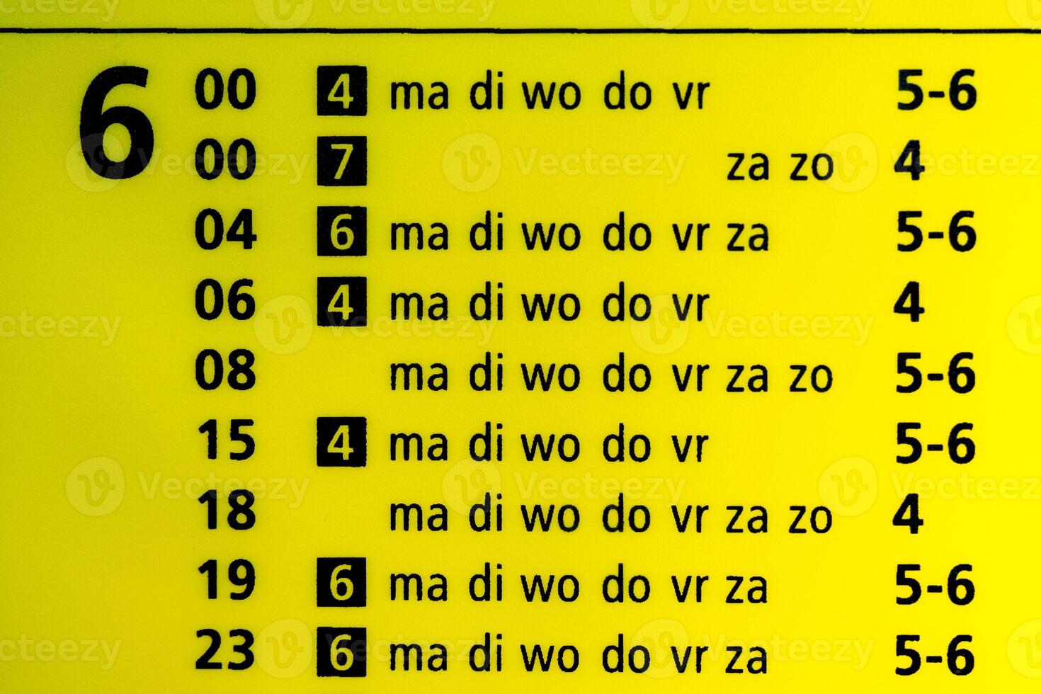 Train departure table for 6am, yellow illuminated. Text is displaying the weekdays mon, tue, wed, thu, fri, sat and sun photo