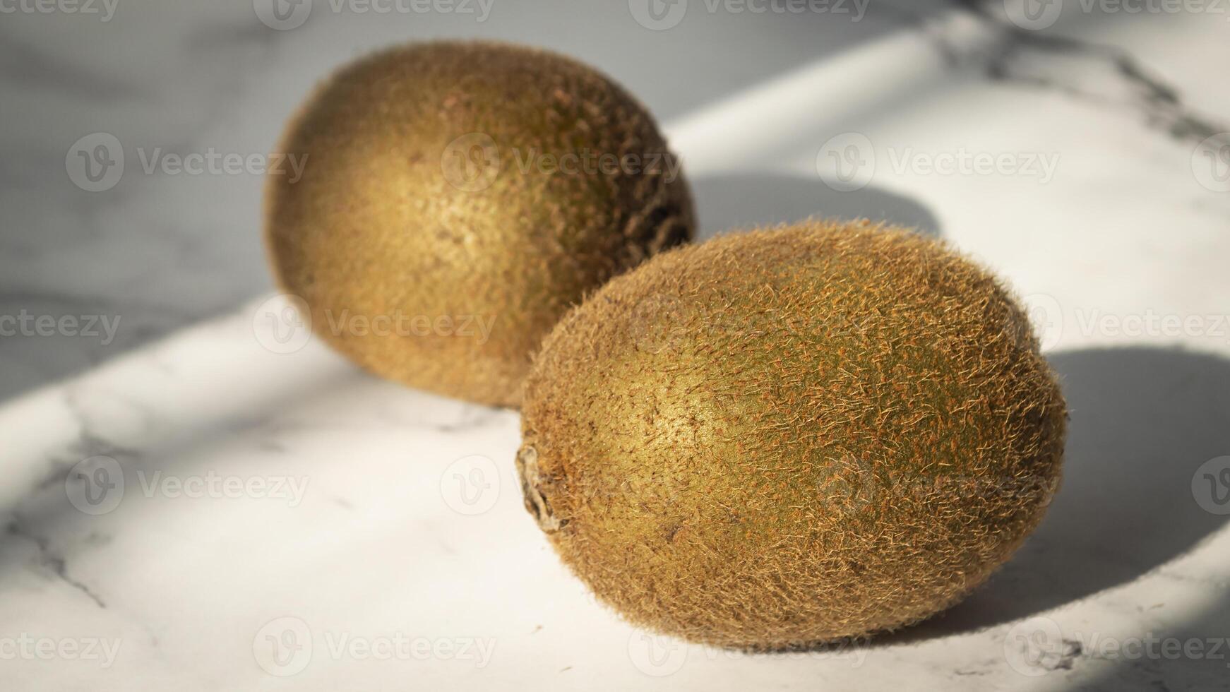 dos kiwis sentado en un mármol superficie foto