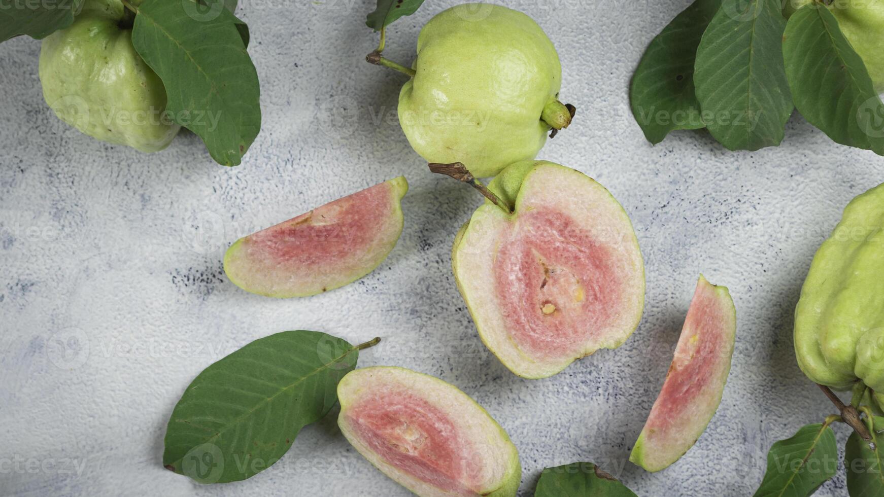 guava fruit with leaves and cut up pieces photo