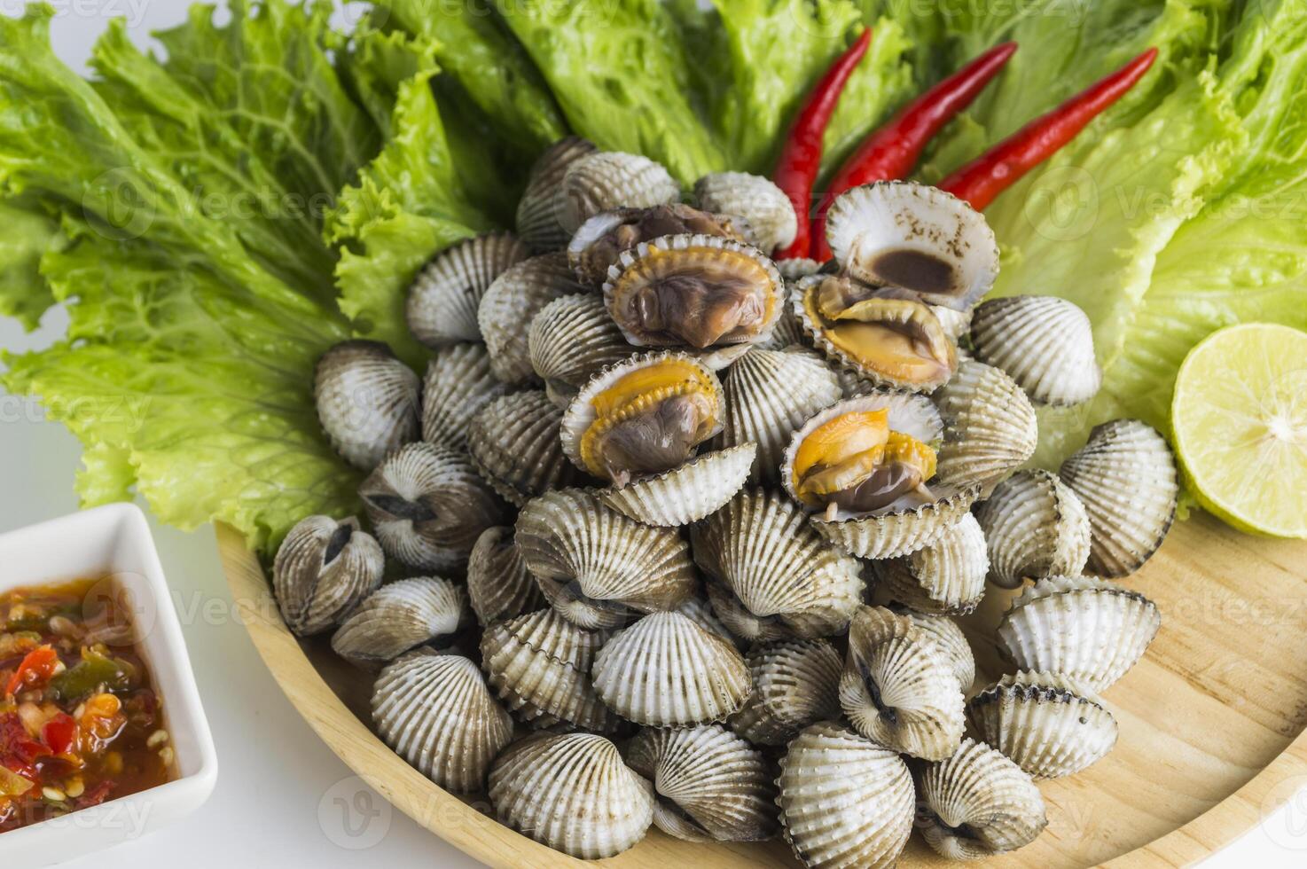 a bowl of clams with a slice of lime and a bowl of lettuce photo
