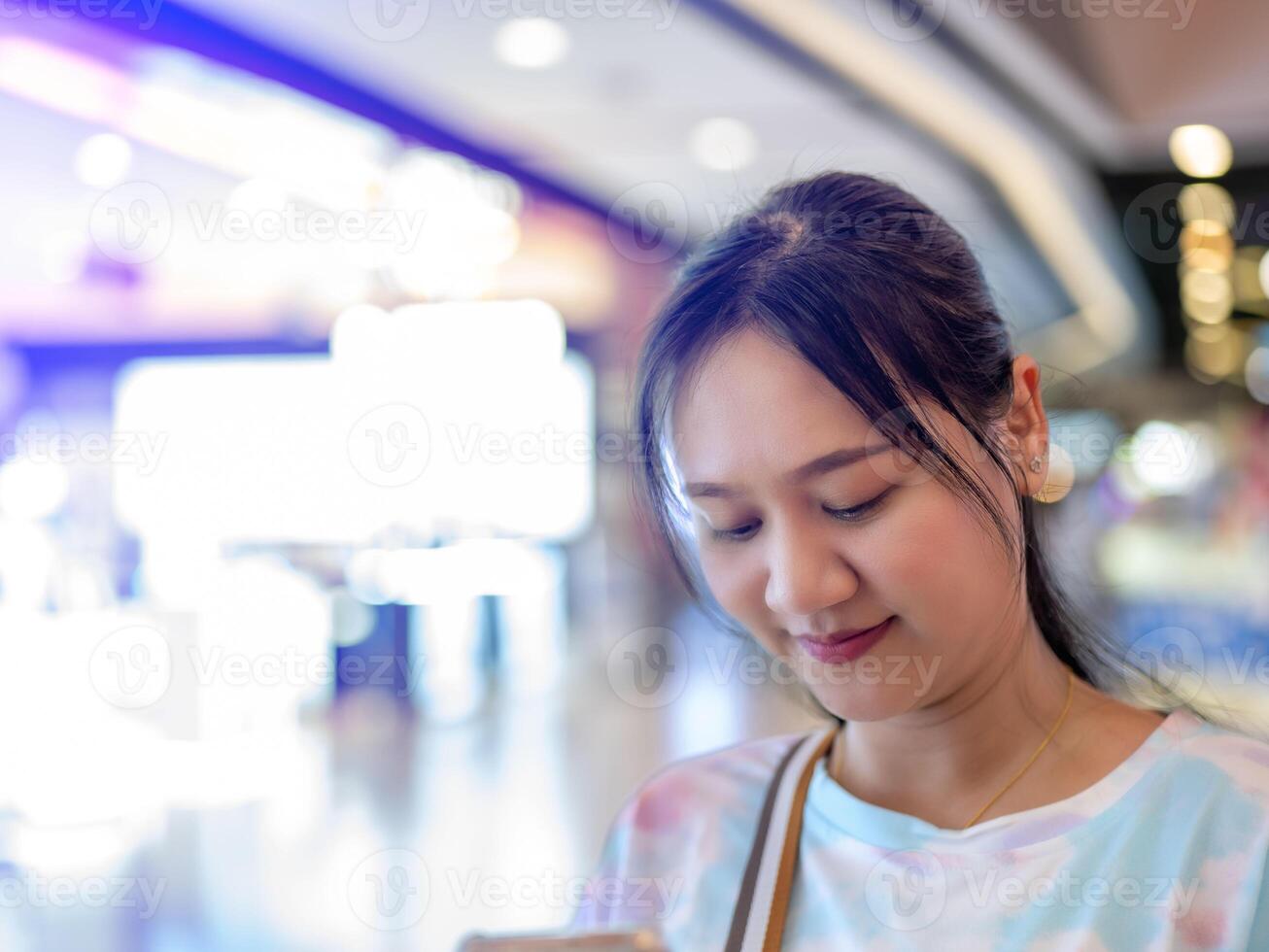 Young Asian woman browsing something mall-themed. Head shot, copy space included. photo
