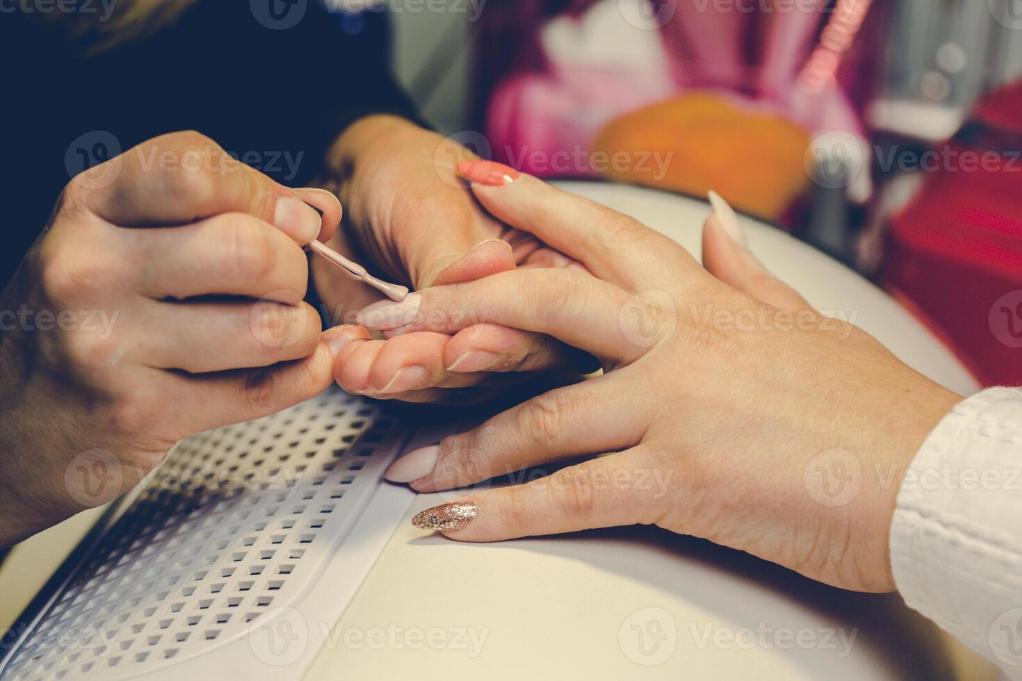 Girl paint nails in the salon of manicure, close-up photo