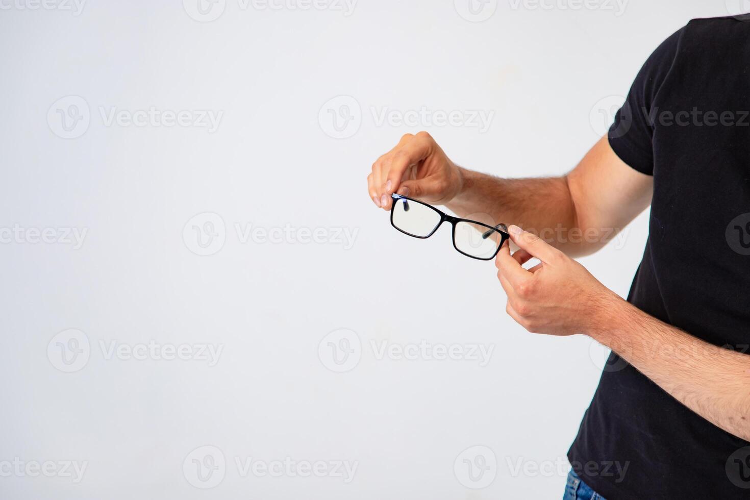 de moda lentes con un negro marco son en el manos de un hombre en un blanco antecedentes en el estudio. foto