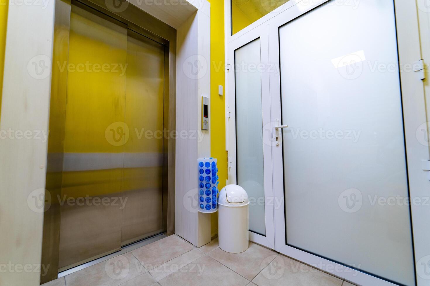 Laboratory front door, medicine, science, health care, emergency and interior concept - doors at hospital, lift, shoe cover box and trash bin. photo