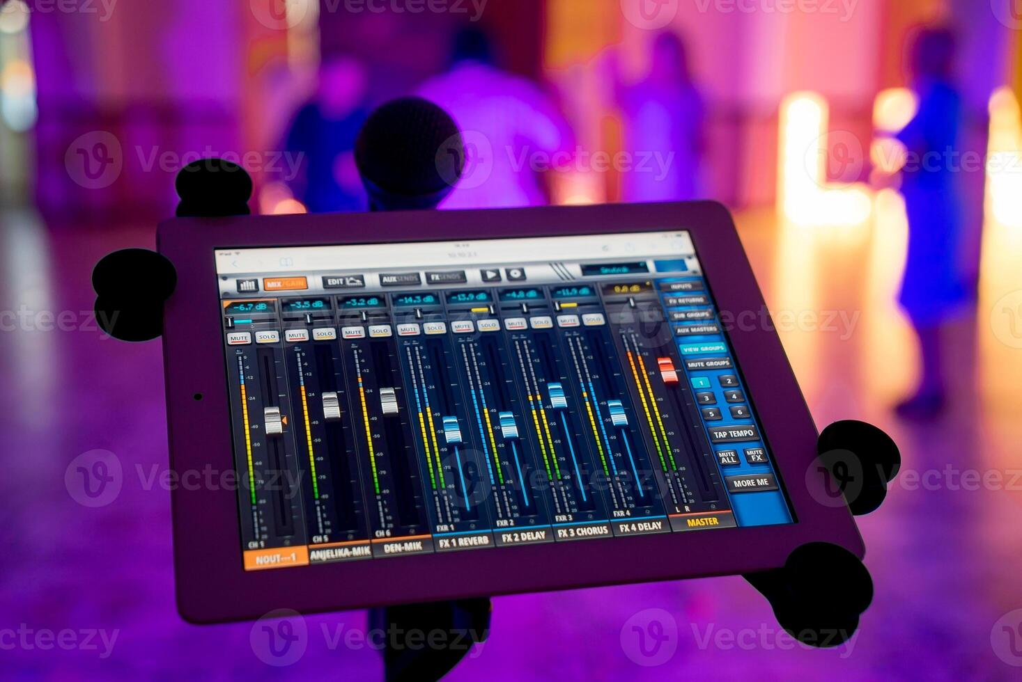 Sound and light mixer console on tablet with microphone over the blurred background. Recording mixing panel with digital mixer tablet in music studio. photo