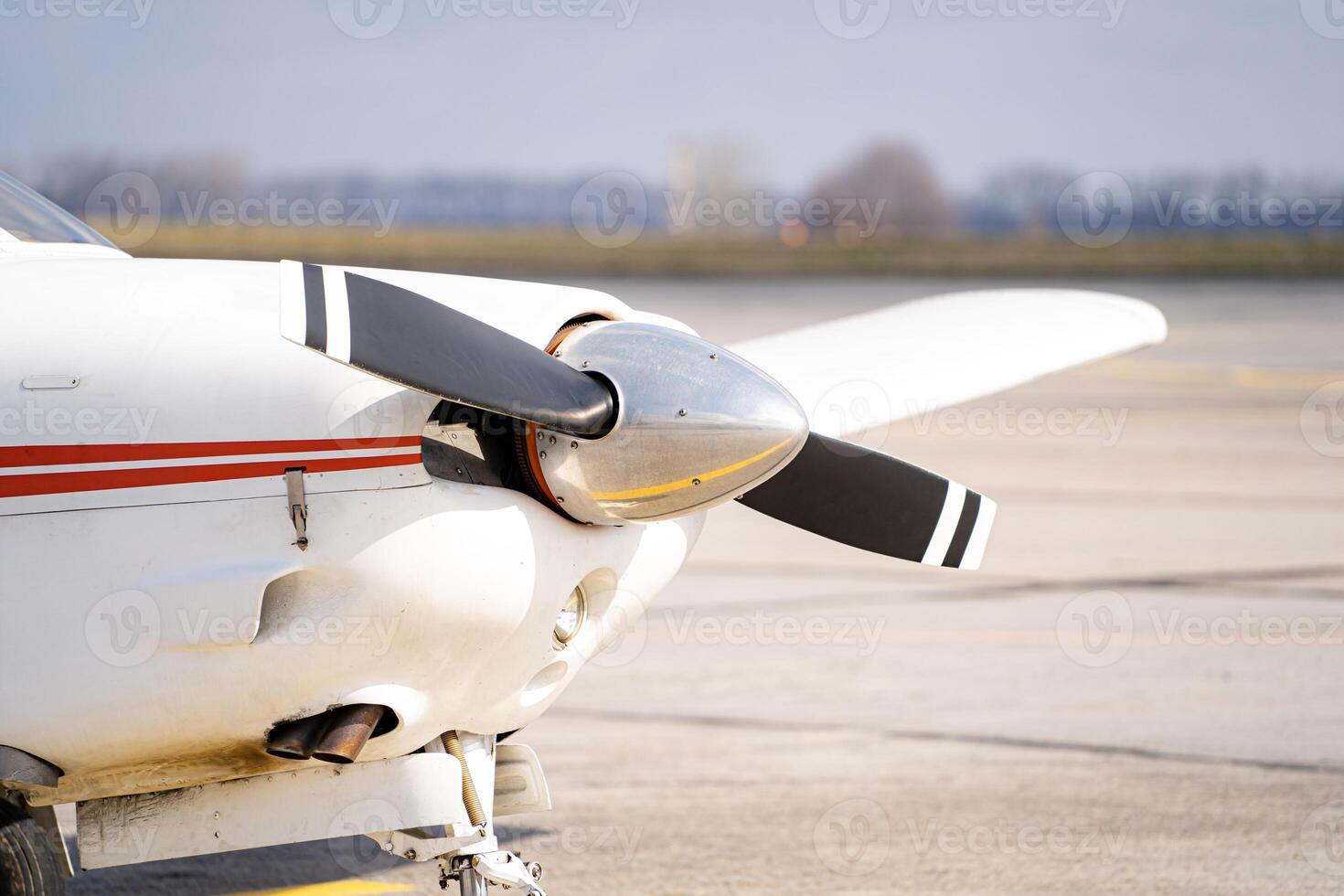 Close up front side of white modern jet plane. Clear background with wide road and trees. photo